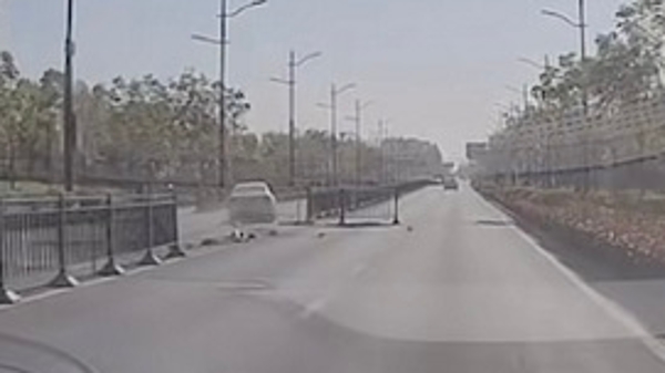 绥宁路瞠目一幕！轿车撞倒一排隔离栏后逆行而去