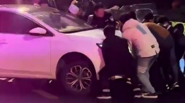 轿车与电动自行车相撞  驾驶员卷入车底  热心市民抬车救人
